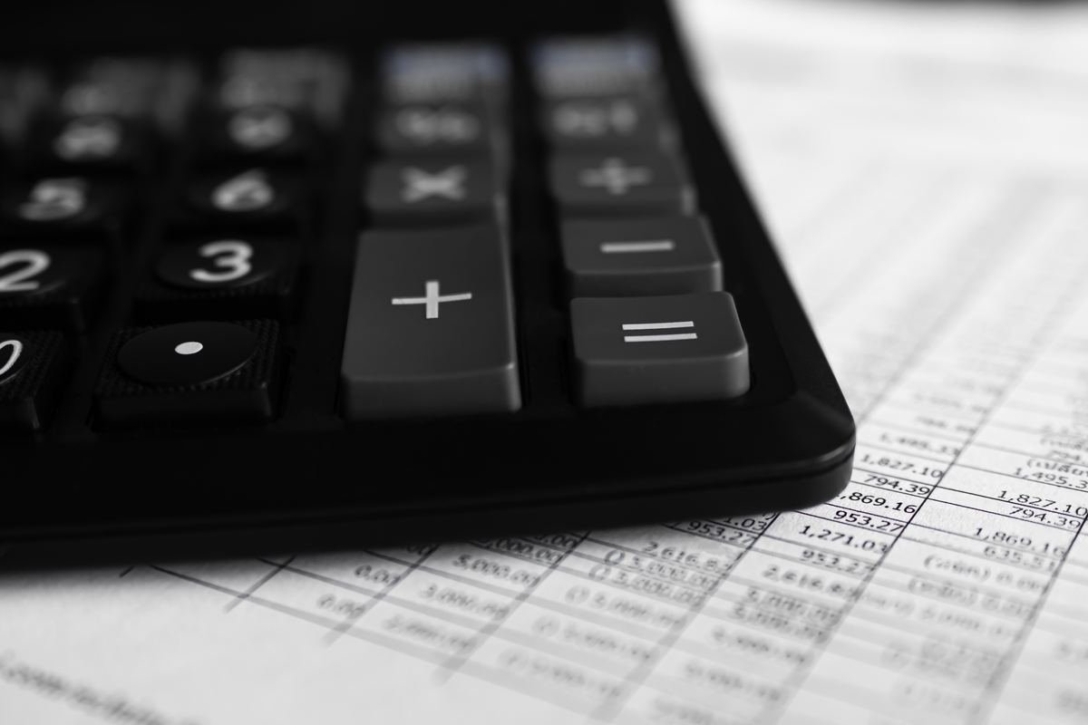 Black calculator resting on a printed spreadsheet